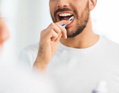 Nose-to-chest view of man brushing teeth