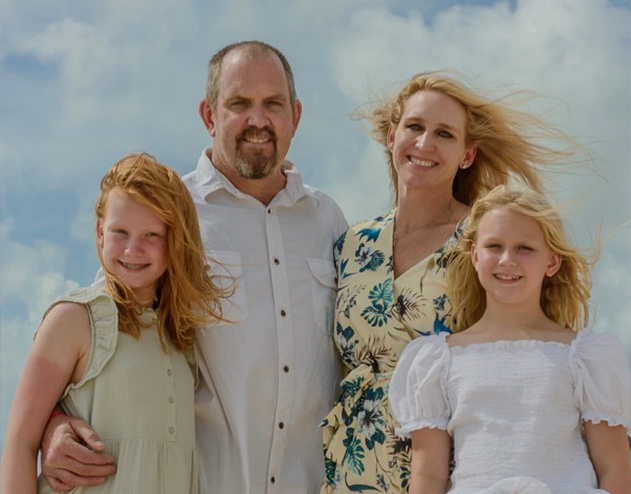 Doctor Thompson smiling with his wife and two children