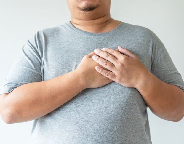 Large man holding his hands over his heart