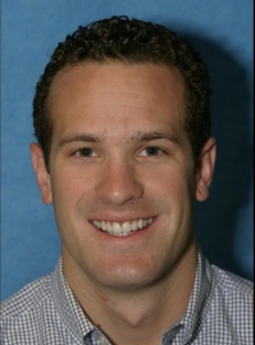 Man with curly hair smiling after dental work