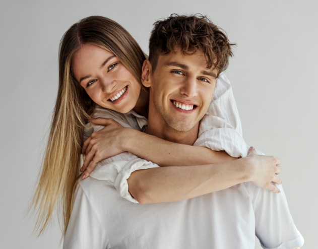 Smiling young man and woman holding each other