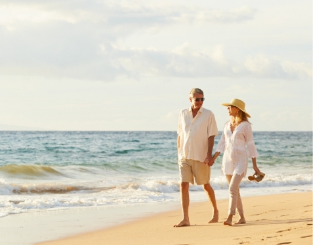 Older man and woman walking on the beach