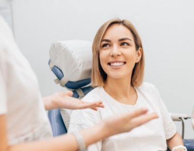 Woman in dental chair smiling at her dentist