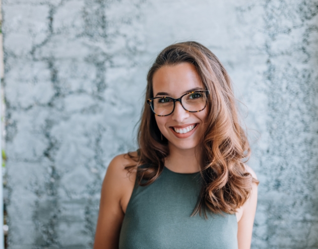 Young woman with glasses smiling after gum disease treatment in Castle Rock