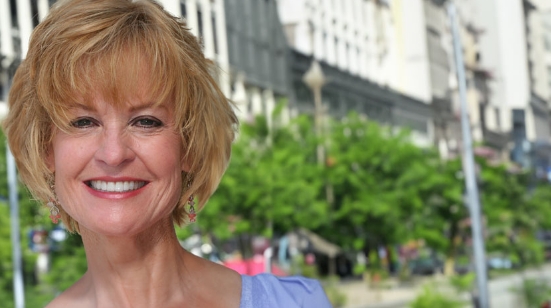 Woman smiling with city street in background