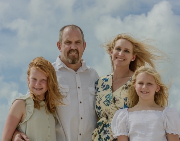 Doctor Thompson smiling with his wife and two children