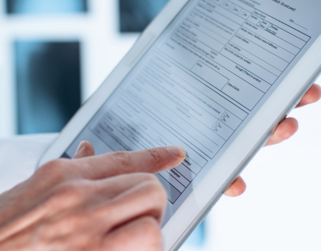 Person filling out dental patient forms on tablet