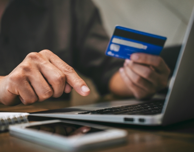 Person typing in their credit card information on laptop