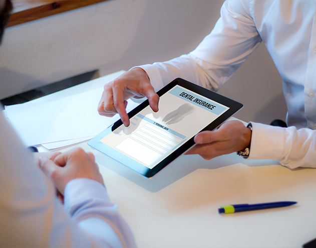 Two people looking at dental insurance information on tablet