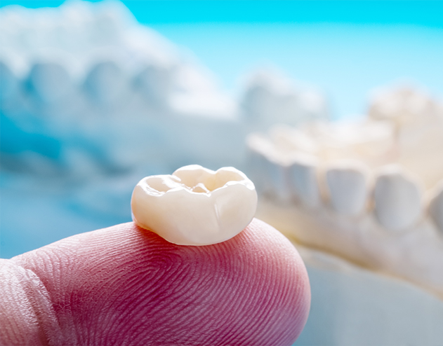 Dental crown resting on a finger