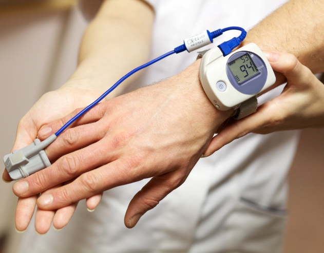 Person wearing pulse oximeter in their hand