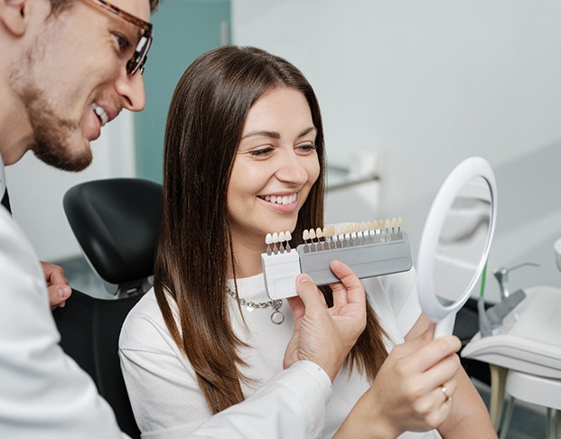 Dentist and patient looking at shade scale
